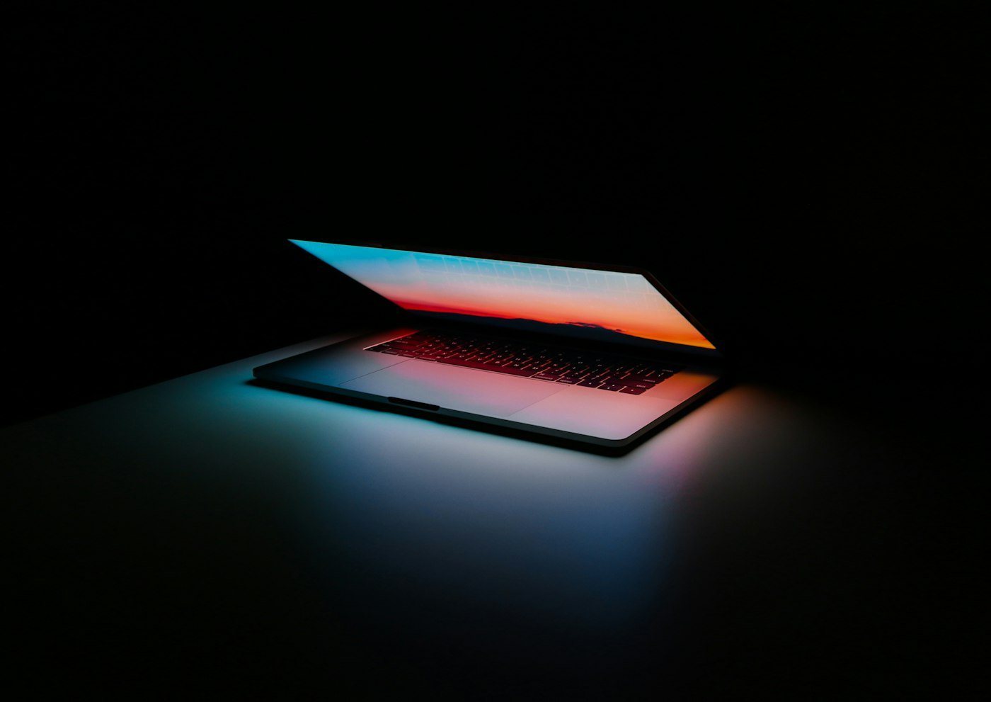 Laptop z jasnym ekranem na ciemnym blacie